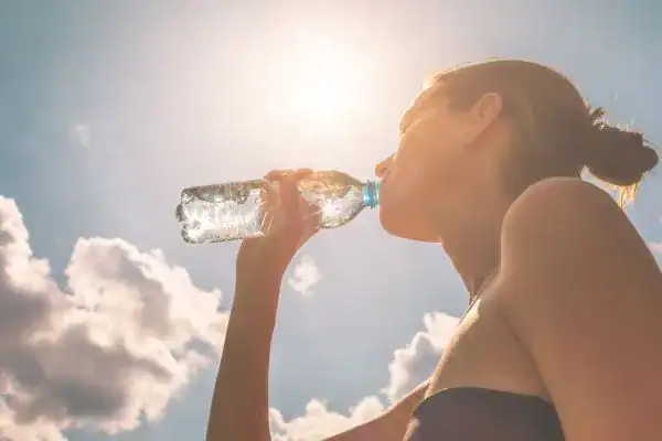 Hydration: The Secret Ingredient for a Toned Stomach and Enhanced Fitness 3 Image of woman drinking water to hydrate Watford after run.